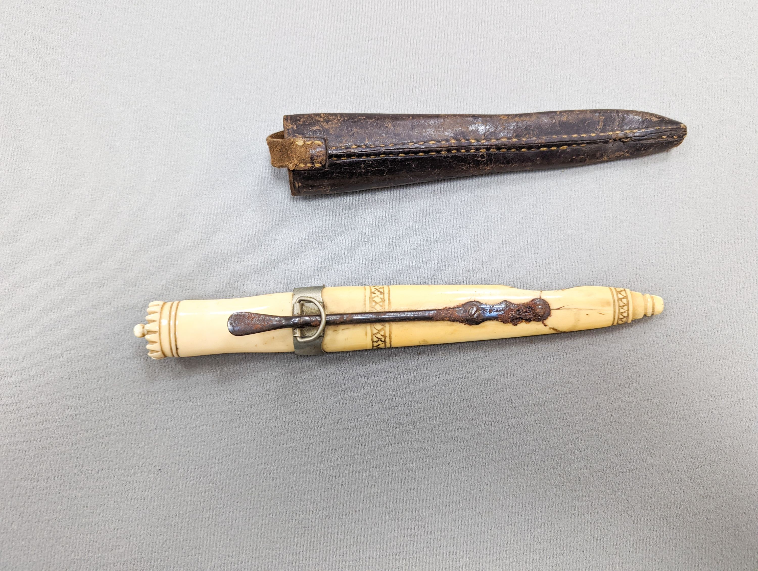 An antique Norwegian marine ivory hunting knife, with carved and pierced scabbard and leather outer sheath, the blade signed Blikstad, Trondhjem, scabbard damaged, overall 26.5cm.